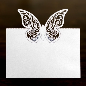 Détail macro du marque-place papillon blanc découpé au laser avec motifs floraux