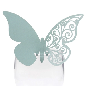Detail view of light green butterfly paper card with laser-cut lace design for wine glasses