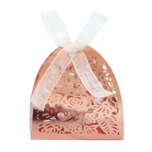 Détail de la boîte à bonbons découpée au laser avec finition rose doré et ruban blanc