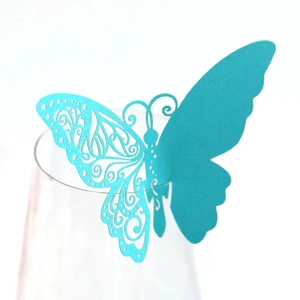 Detailed laser-cut cyan butterfly place card on a wine glass for wedding table decor