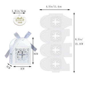 Gros plan d'une boîte cadeau blanche ajourée au laser avec croix et étiquette merci