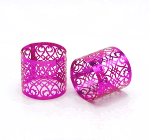 Close-up of two purple hollow-out geometric laser cut napkin rings with metallic finish