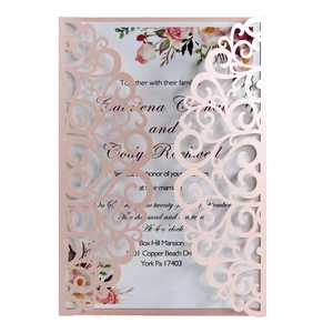 Detail of laser cut lace wedding invitation with floral scroll patterns and inner card