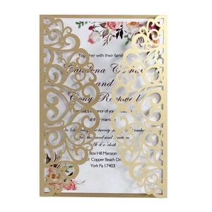 Detail of laser-cut gold wedding invitation with floral patterns and pearl paper texture