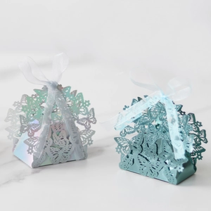 Detail of laser-cut butterfly favor boxes in metallic blue and iridescent finish
