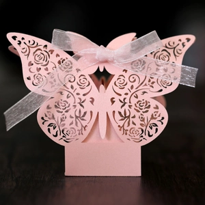 Macro detail of laser-cut pink butterfly candy box with rose patterns and ribbon