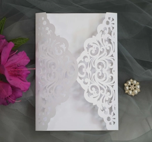 Detail of laser cut lace pattern on white pearlescent wedding invitation card sleeve