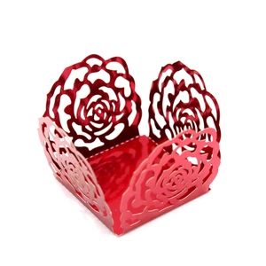 Detail of red hollow rose laser-cut cake lace wrapper with glossy reflective finish