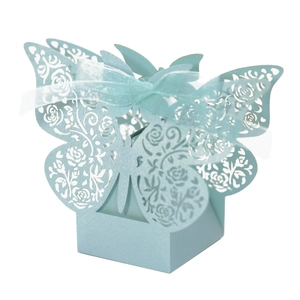 Macro shot of light blue laser-cut butterfly candy box with floral patterns and ribbon