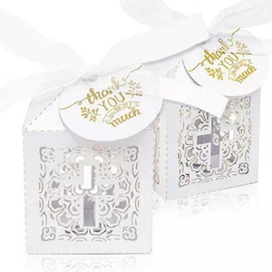 Détail de boîtes à bonbons découpées au laser avec motif croix et étiquette de remerciement dorée