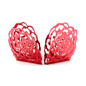 Macro detail of red laser-cut cupcake wrapper with intricate rose pattern and pearlescent finish