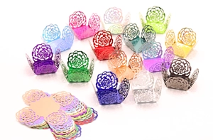 Macro view of laser-cut rose floral hollow cupcake wrappers in metallic mirror finishes