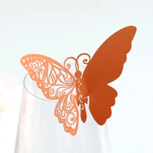 Detail of laser-cut butterfly paper wine glass card in orange for table setting decor