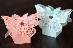 Detail of laser cut butterfly candy boxes with rose patterns and matching organza ribbons