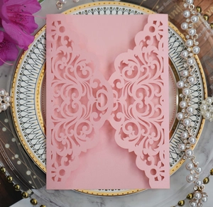 Intricate laser-cut pink wedding invitation cover on elegant pearl paper with floral patterns