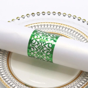 Close-up of laser-cut hollow vine pattern napkin ring in glossy green finish