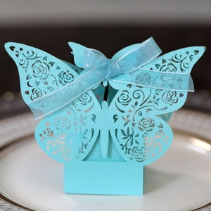 Detailed laser-cut blue butterfly favor box with rose patterns and matching ribbon bow