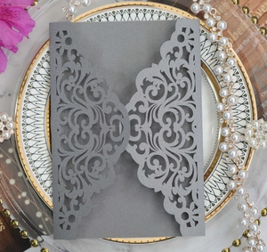 Detail of laser-cut floral pattern on grey pearlescent wedding invitation sleeve