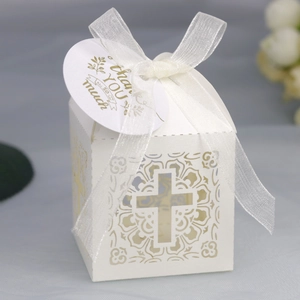 Détail de la boîte cadeau blanche découpée au laser avec croix et ruban élégant