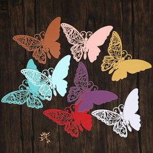Detailed laser-cut paper butterflies in vibrant colors on a dark wood background