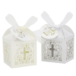 Détail de boîtes cadeaux blanches découpées au laser avec motif croix et étiquettes merci