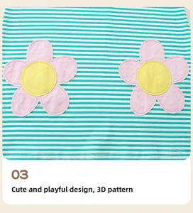 Dettaglio di un abito a righe verdi e bianche per bambine con fiori rosa 3D ricamati