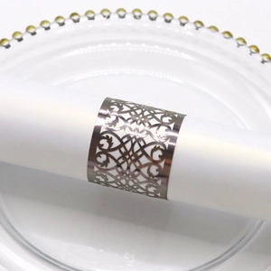 Detailed view of silver metallic napkin ring with vintage hollowed floral patterns