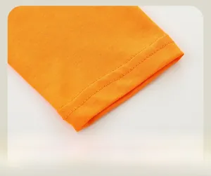 Detailed close-up of orange cotton knit cuff with neat double-needle stitching and texture