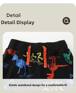 Détail du pantalon de sport enfant avec taille élastique, cordon orange et motif dinosaure