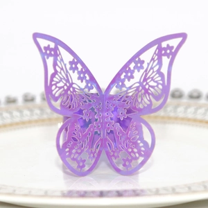 Dettaglio macro del portatovagliolo a farfalla viola intagliato al laser su piatto bianco