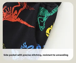 Détail de la poche latérale et de l'imprimé dinosaure coloré sur ce pantalon pour enfant