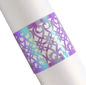 Close-up of laser-cut napkin ring with iridescent purple metallic gradient and intricate patterns