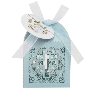 Détail boîte cadeau bleu clair découpée au laser avec croix et carte de remerciement