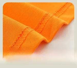 Macro shot of double-needle stitching on the hem of a soft orange cotton knit shirt