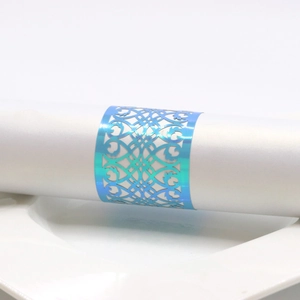 Macro detail of holographic blue laser-cut napkin ring with ornate European pattern