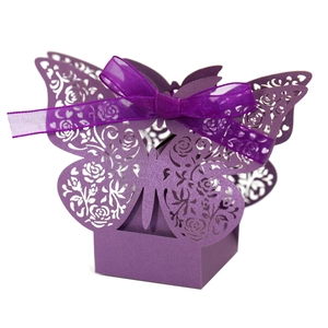 Detail of laser-cut rose patterns on dark purple wedding candy box with ribbon