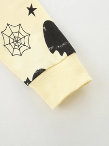 Close-up of yellow Halloween sweatshirt cuff with spider web and ghost print for boys