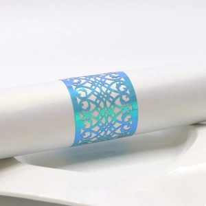 Macro view of blue iridescent paper napkin ring with hollow laser-cut scroll pattern