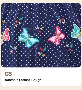 Detail view of butterfly embroidery and polka dot patterns on navy blue kids dress fabric