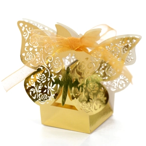 Macro view of gold laser-cut butterfly candy box with rose patterns and ribbon