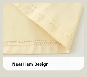 Detail showing neat double-needle stitching on the hemline of yellow cotton kid shirt