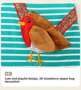 Détail d'une robe rayée pour fille avec poche oiseau en peluche 3D et broderie florale