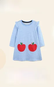 Détail d'une robe en coton rayé pour fille avec volants et poches de pommes rouges