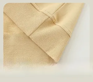 Close-up of ribbed hem on light yellow kids sweatshirt with double-needle stitching detail