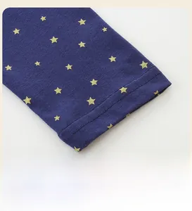 Detail of navy blue long sleeve cuff with golden star print and double needle stitching
