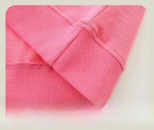 Détail du sweat-shirt rose en coton montrant l'ourlet côtelé et la double couture