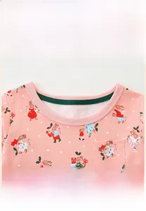 Gros plan du col rond renforcé d'une robe rose pour fille avec motifs de lapin de Noël