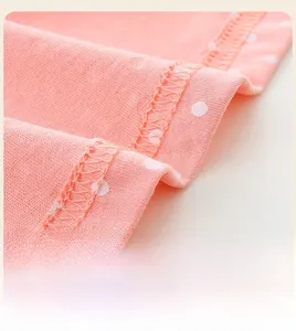 Détail de la robe rose corail à pois montrant les coutures soignées de l'ourlet en A