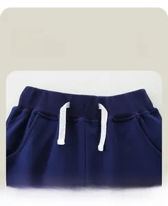 Detail view of navy blue kids' joggers with elastic ribbed waistband and cotton drawstrings