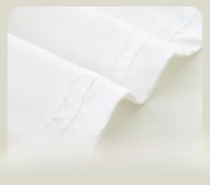 Close-up of neatly stitched double-line hem on a white cotton long-sleeve tee